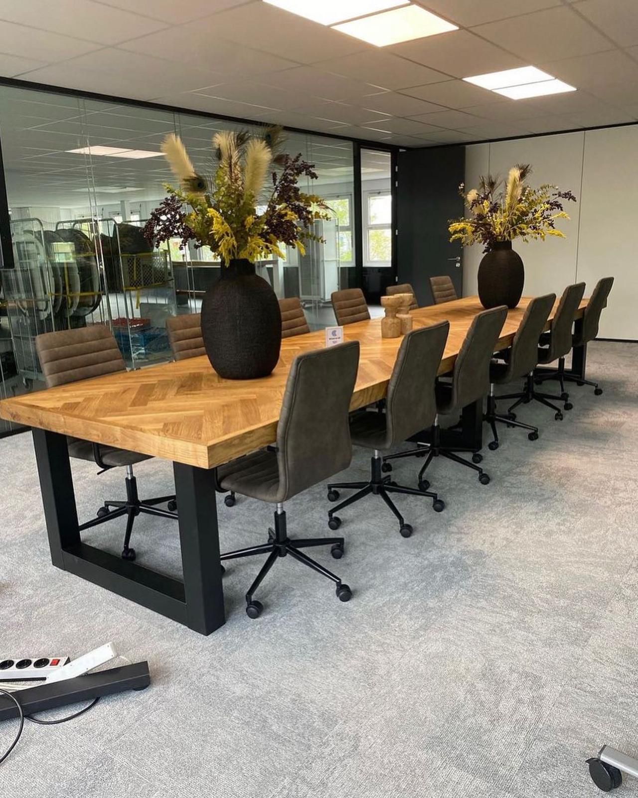 Grote maatwerk vergadertafel met visgraat blad en stalen onderstel